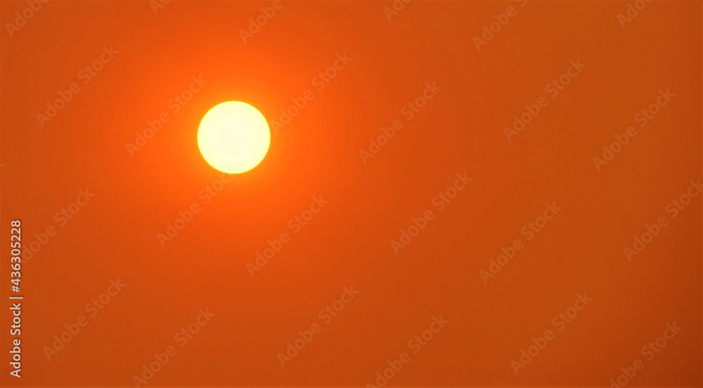 Close up of an orange sun with wild fire smoke in the air