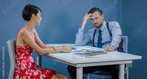 Woman in the interrogation room, looking at photos of gangsters