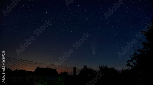 Beautiful view of the starry sky and comet C / 2020 F3 (NEOWISE) with a light tail. a fascinating view from the window of your house outside the city.
