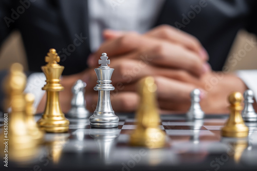 chess King figure against chessboard opponent with businessman manager background. Strategy, Success, management, business planning, tactic, politic, thinking, vision and leadership concept