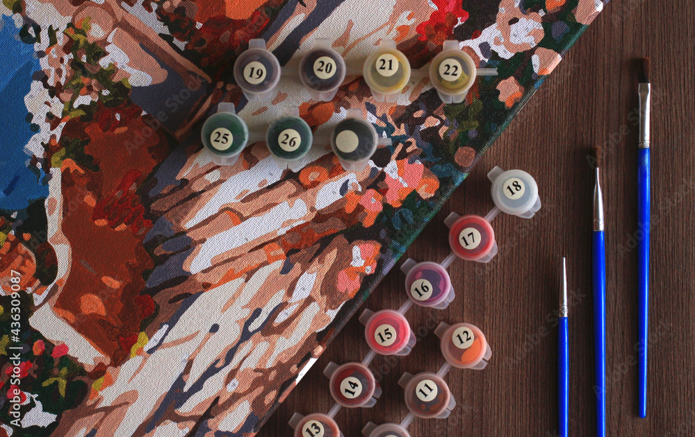 Fototapeta premium painting coloring by numbers with acrylic paints in small jars with brushes