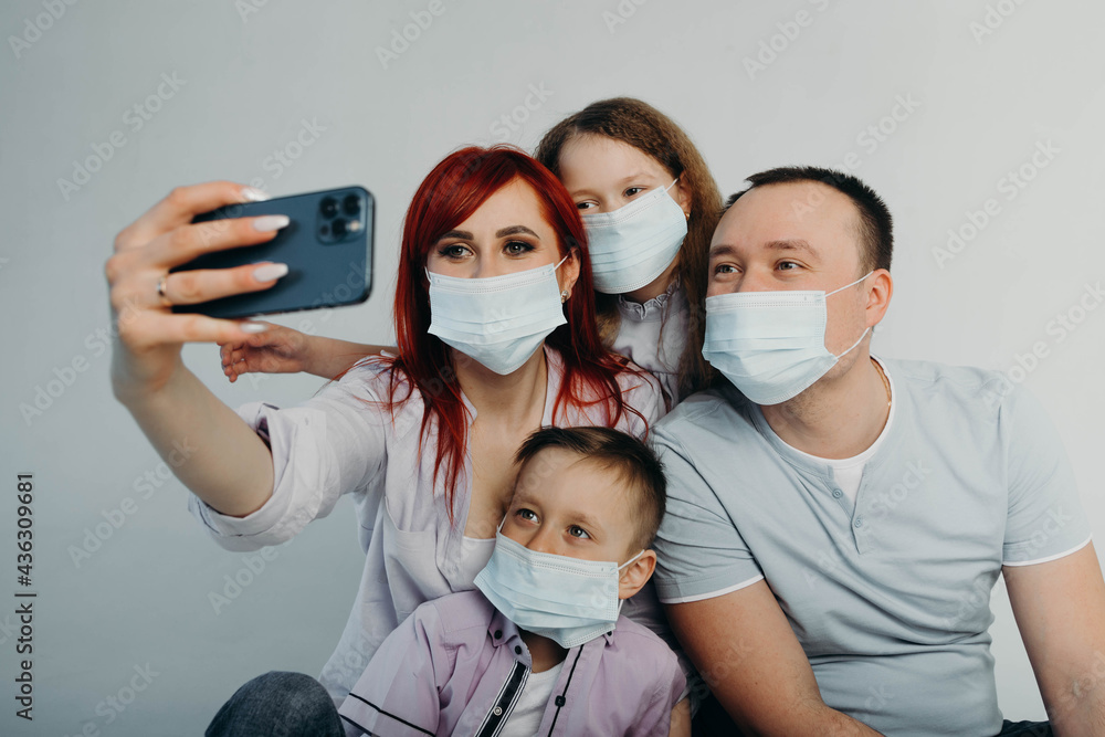 An international family in masks takes a selfie. Coronavirus.