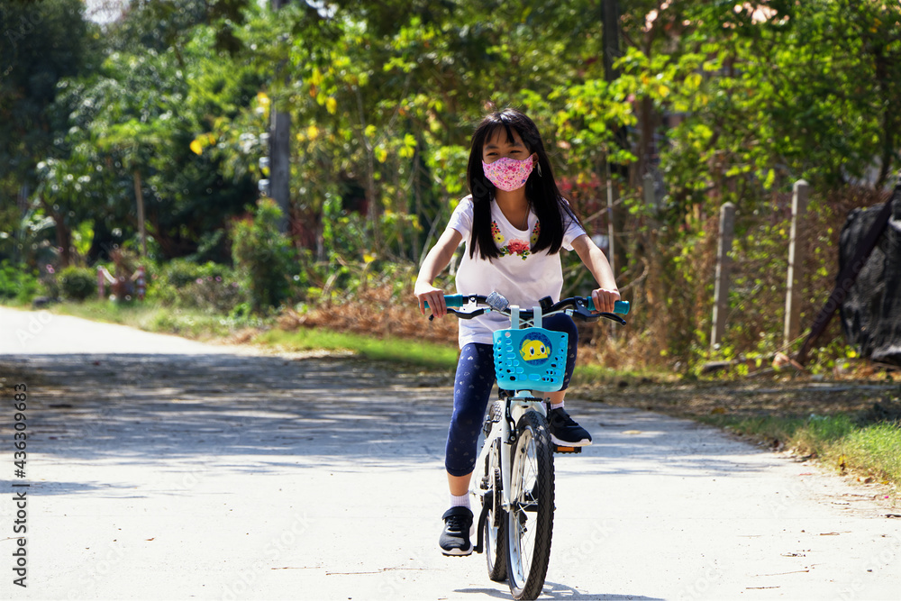 Asian child bike outdoor with mask. New normal collections