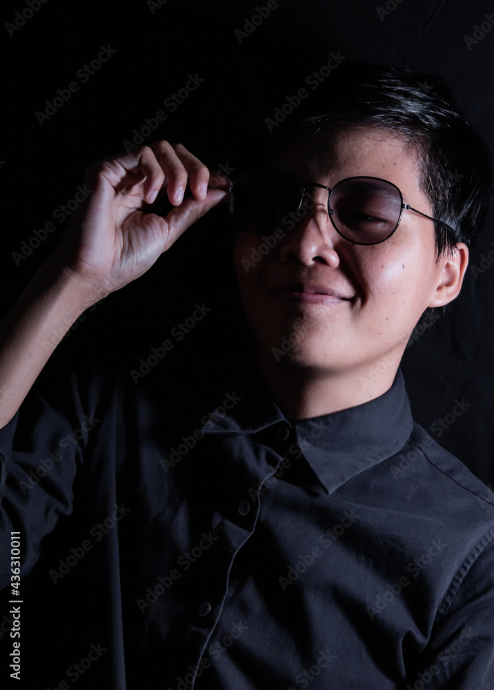 Smiling Asian woman aged the 30s. wearing glasses Making the face look with short hair wearing a blue shirt. Standing looking at the camera, single person photo. Black and white portrait people Smiling Asian woman aged the 30s. wearing glasses Making the face look with short hair wearing a blue shirt. Standing looking at the camera, single person photo. Black and white portrait people