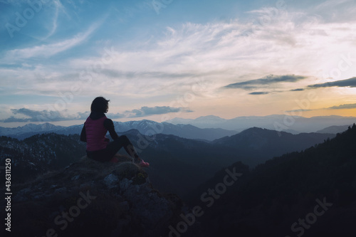 Girl tourist enjoying the mountain landscape at sunset.