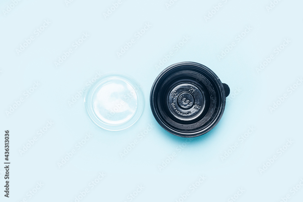 empty plastic bowl with open lid on a light blue background. Top view, flat lay