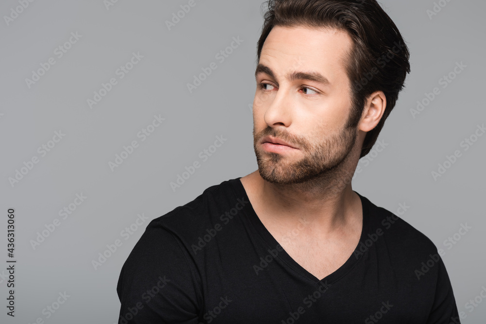 bearded and good-looking man in black t-shirt looking away isolated on gray. bearded and good-looking man in black t-shirt looking away isolated on gray.