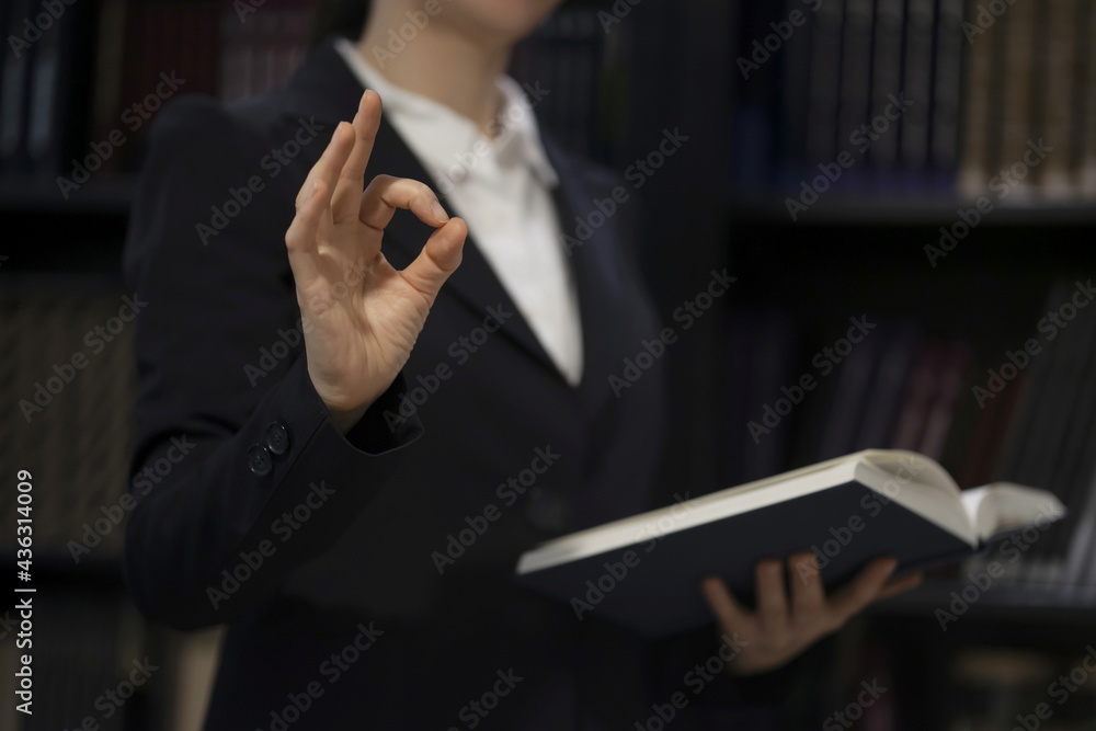 Lawyer showing ok sign with book