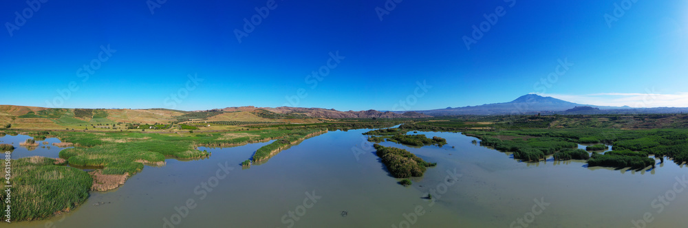 180 degrees aerial photo of the Oasis of Ponte Barca a protected area in the heart of Paternò in Sicily. Wetland that attracts numerous waterfowl. Nesting place of the Sultan chicken. Etna view.