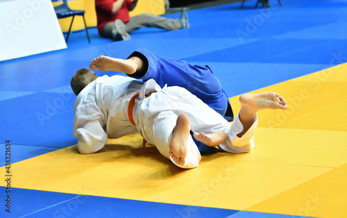 Two Boys judoka in kimono compete on the tatami 