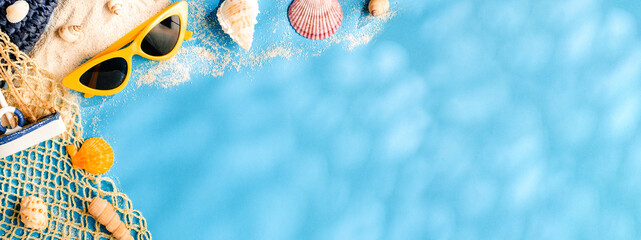 Tropical blue summer sand beach sea with  accessories objects,sunglasses,straw hat and seashell on blue pastel background banner with sunlight