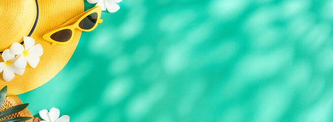 Tropical summer yellow straw hat and singleness on turquoise background with sunlight and shade.banner mockup space for product display advertise