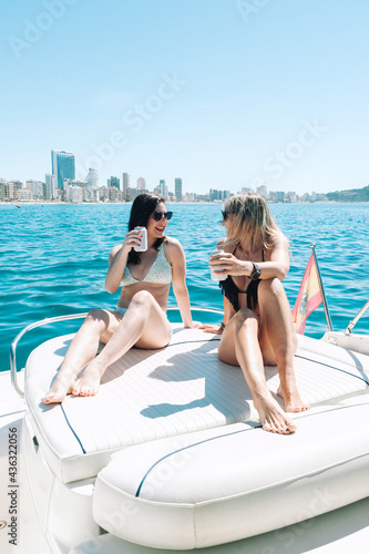Friends toasting drinks in boat party © noeliauroz