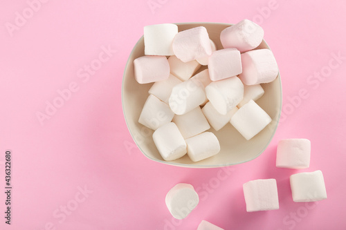 Marshmallow in bowl on pastel pink background.