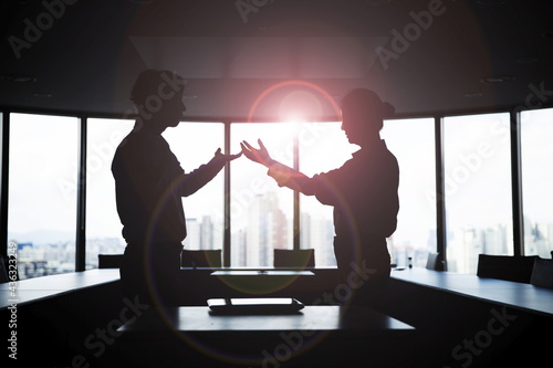 Silhouette business people arguing in meeting room