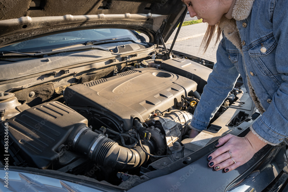 Broken down car. Vehicle engine motor problem concept. Driver girl near open hood auto. Broken down car. Vehicle engine motor problem concept. Driver girl near open hood auto.