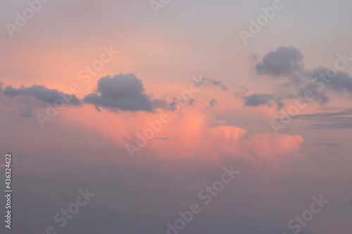 Sky with gray cumulus and layer clouds against orange sunset. Nature background.