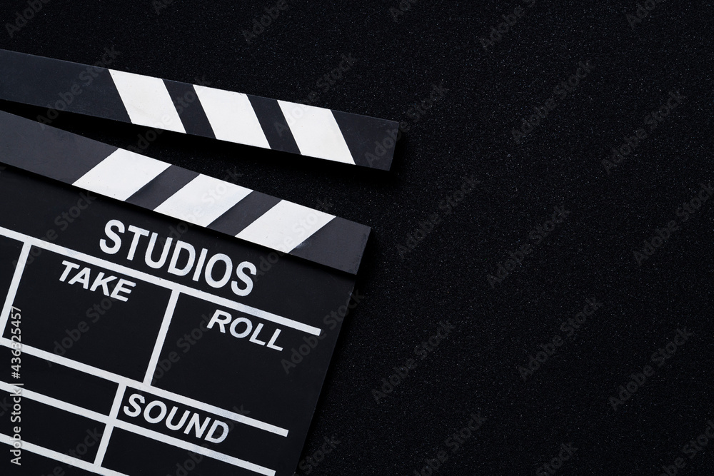 movie clapper on black table background ; film, cinema and video photography concept