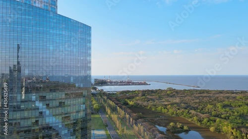 Aerial descending pedestal view of the coastline reflected on a modern building in Puerto Madero, Buenos Aires. photo