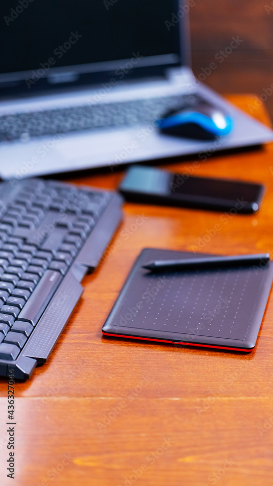 Remote work graphic designer. Freelancer workplace. Laptop, smartphone and graphic tablet in the workplace Remote work graphic designer. Freelancer workplace. Laptop, smartphone and graphic tablet in the workplace