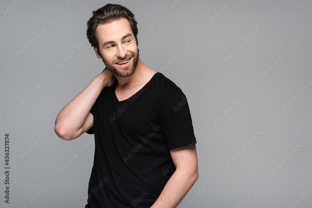 positive bearded man in black t-shirt looking away isolated on grey. positive bearded man in black t-shirt looking away isolated on grey.