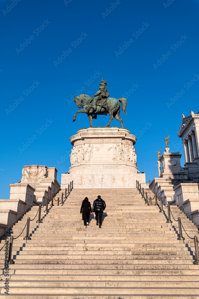 Obraz premium Rome Piazza Venezia Altar of the Fatherland, equestrian monument of Vittorio Emanuele II, Italy. Detail of the staircase with two tourists. Italian National Monument on the Capitoline Hill. Europe.
