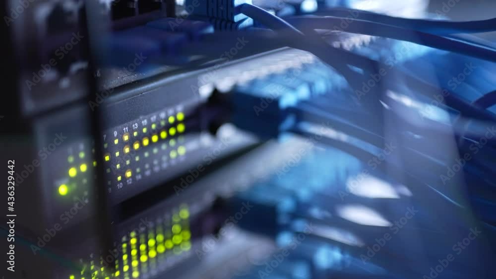 Close up fiber optic in server room. Network cables installed in the rack at data center. Ethernet cable on network switches background