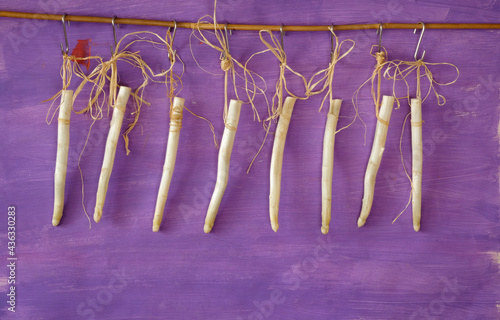 fresh white asparagus hanging on purple background, new asparagus season in the springtime and summer, good copy space