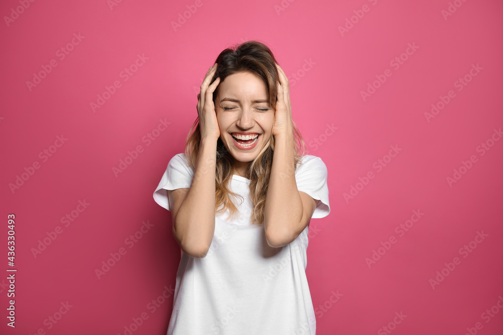Cheerful young woman laughing on pink background Cheerful young woman laughing on pink background