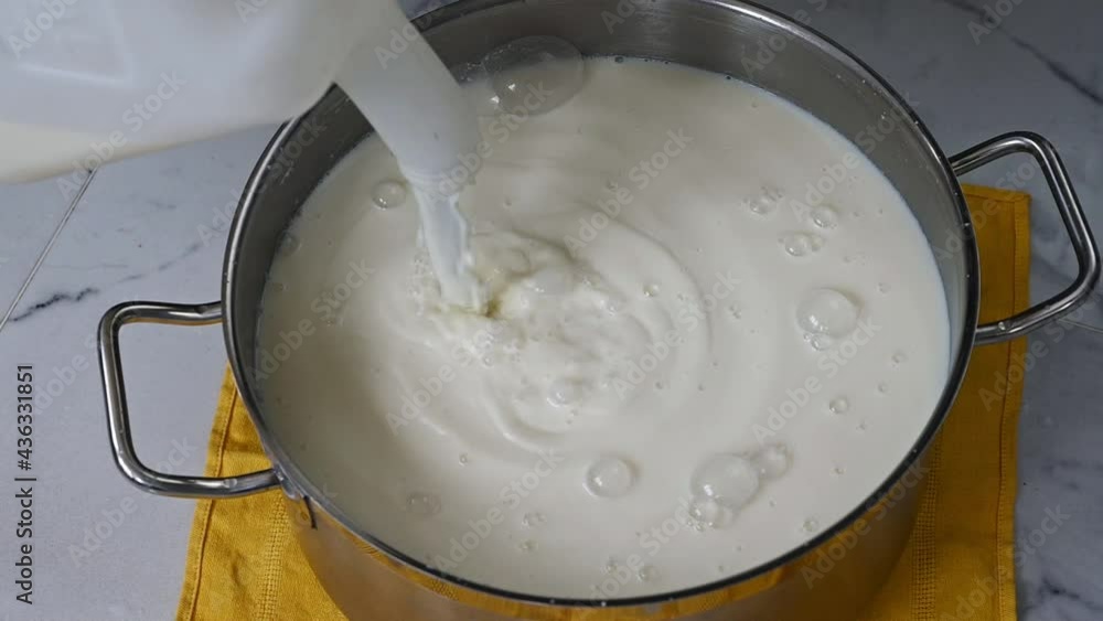 Slow motion of fresh cow's milk being poured from jug into a saucepan to make homemade cheese
Slow motion of fresh cow's milk being poured from jug into a saucepan to make homemade cheese