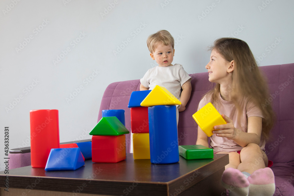 boy and girl play with colorful figures cone cubes build a house tower, brother and sister have fun boy and girl play with colorful figures cone cubes build a house tower, brother and sister have fun