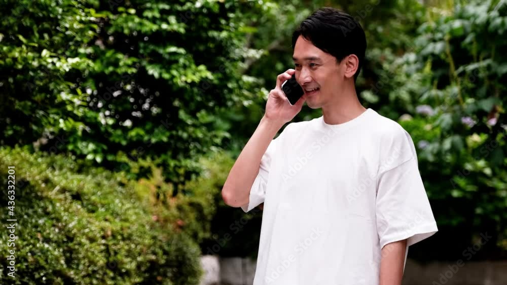 スマホで通話する白いシャツの男性 スマホで通話する白いシャツの男性