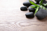 Spa stones and bamboo sprout on wooden table, space for text