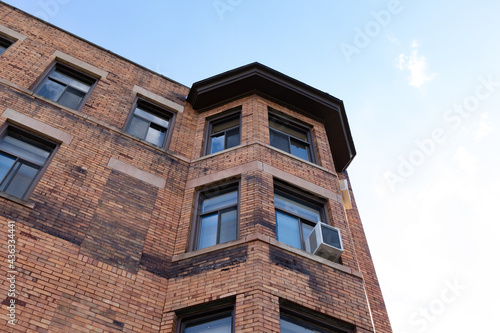 Very old brick apartment building with new replacement windows, horizontal aspect