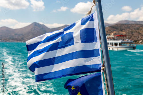 Greek waving flag on a ship off the Greek coast