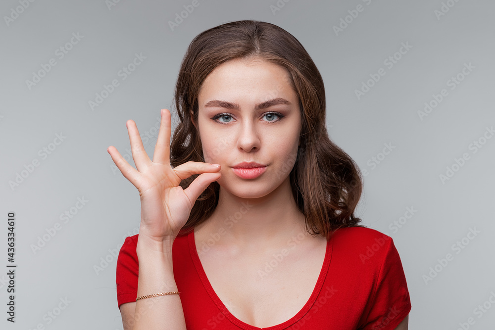 Your secrets safe with me concept. Young brunette woman showing zip gesture as if shutting mouth on key. Keep a secret Your secrets safe with me concept. Young brunette woman showing zip gesture as if shutting mouth on key. Keep a secret