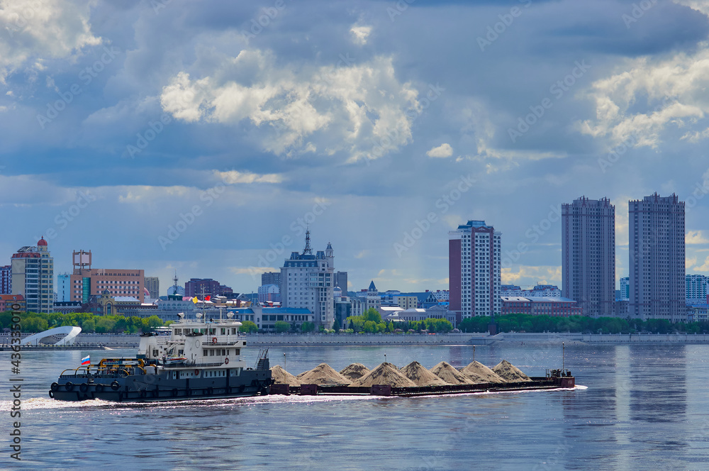 A barge loaded with building materials moves along the Amur River.