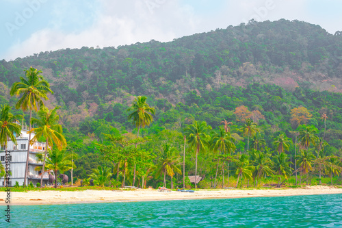 Tropical seaside with green mountains and palm trees. Holidays in Asia on an island in Thailand. Travel and tourism.