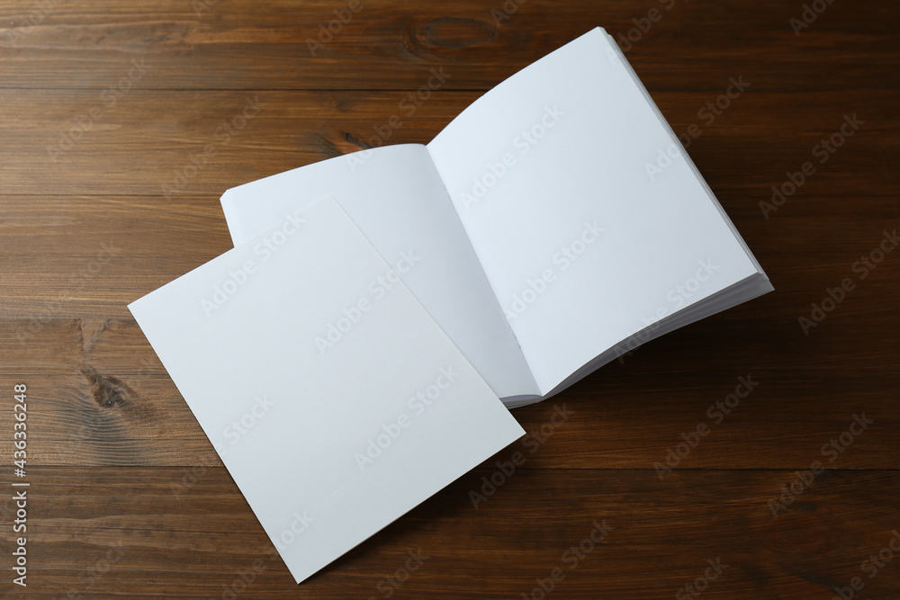 Sheet of paper and blank brochure on wooden table. Mockup for design Sheet of paper and blank brochure on wooden table. Mockup for design