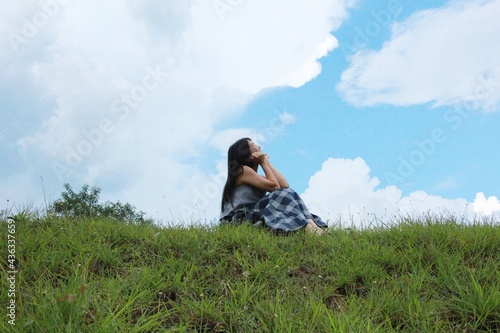woman sitting looking onto the sky happily