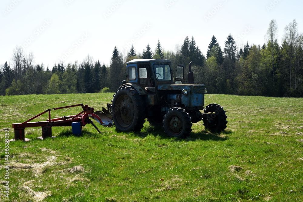 Naklejka premium Old blue russian agricultural tractors in the field. Agricultural machinery in the farm. Special Agricultural Equipment