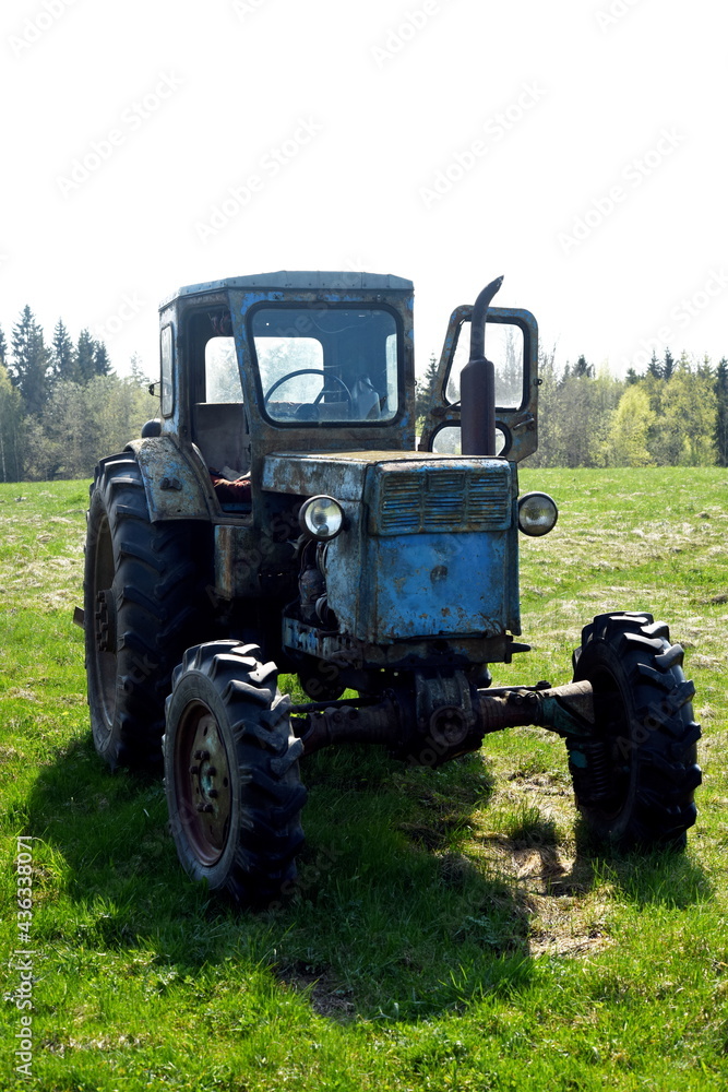 Old blue russian agricultural tractors in the field. Agricultural machinery in the farm. Special Agricultural Equipment Old blue russian agricultural tractors in the field. Agricultural machinery in the farm. Special Agricultural Equipment