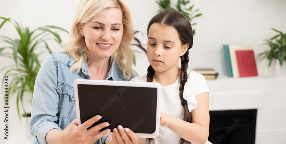 Back to school. Happy child and adult are sitting at desk. Girl doing homework or online education. Back to school. Happy child and adult are sitting at desk. Girl doing homework or online education.