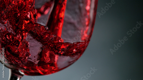 Glass of red wine on dark background closeup photo