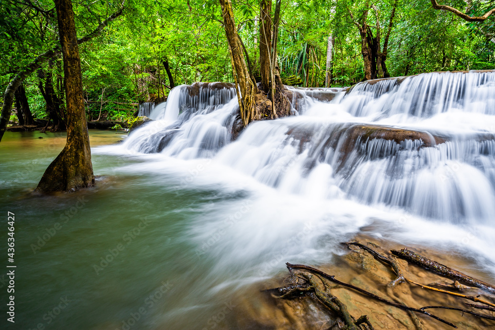 Obraz premium Waterfall and blue emerald water color in Huay Mae Khamin national park. Huay Mae Khamin, Beautiful nature rock waterfall steps in tropical rainforest at Kanchanaburi province, Thailand