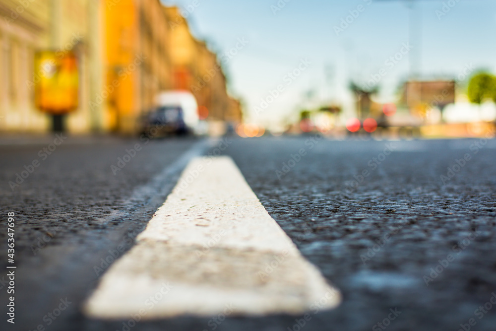 Clear day in the big city, the lights of the approaching cars. View of the road at the level of the dividing line Clear day in the big city, the lights of the approaching cars. View of the road at the level of the dividing line