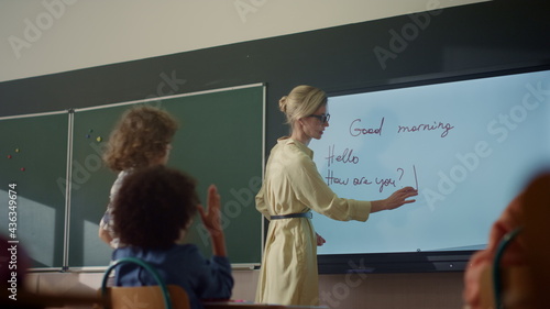 Teacher using interactive digital whiteboard. Student writing on smart board