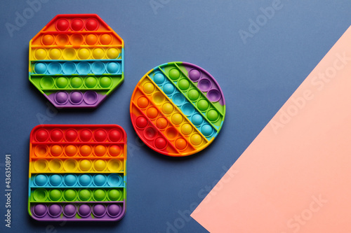 Rainbow pop it fidget toys on color background, flat lay. Space for text