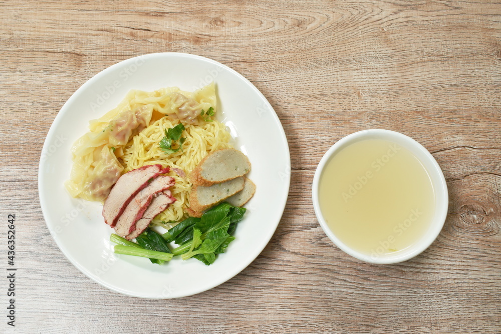 Chinese egg yellow noodles with barbecue pork and dumpling on plate with soup cup Chinese egg yellow noodles with barbecue pork and dumpling on plate with soup cup
