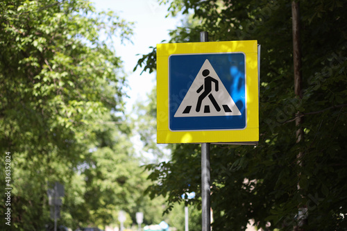 Pedestrian crossing road sign on yellow background